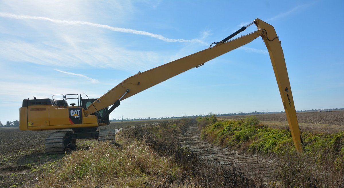 The Cat long reach excavator shapes slopes